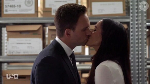 Meghan Markle embrasse son partenaire Patrick J. Adams dans la série "Suits" le 29 mars 2018.
