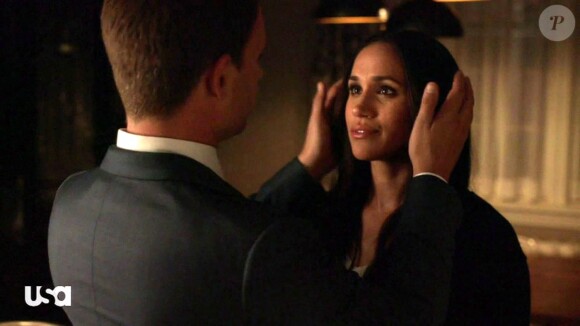 Meghan Markle embrasse son partenaire Patrick J. Adams dans la série "Suits" le 29 mars 2018.