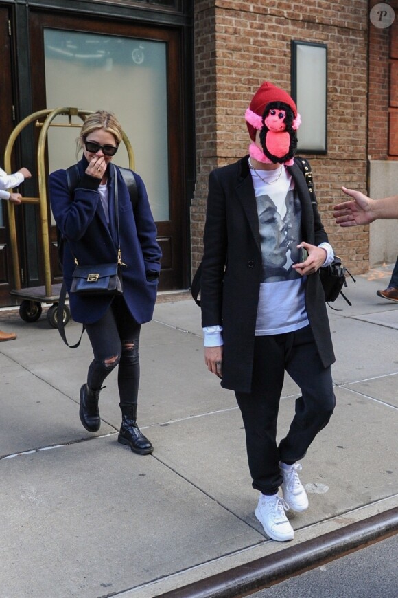 Cara Delevingne s'est cachée le visage par un singe en peluche rose à New York, elle est accompagnée de son amie Ashley Benson, le 19 octobre 2018.