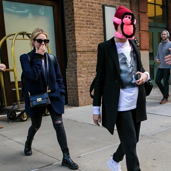 Cara Delevingne s'est cachée le visage par un singe en peluche rose à New York, elle est accompagnée de son amie Ashley Benson, le 19 octobre 2018.