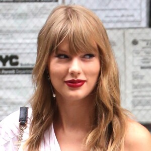 Taylor Swift quitte son appartement à New York. La chanteuse porte un mini short en jean, une blouse blanche et des bottines noires à talons, le 22 juillet 2018.