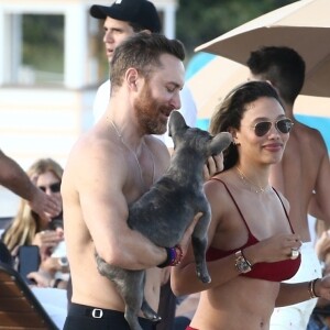 David Guetta et sa compagne Jessica Ledon, qui porte un diamant à l'annulaire gauche, passent du bon temps sur la plage en compagnie de leur petit chien. Miami, le 23 novembre 2018.