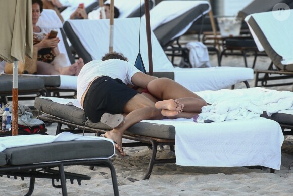 David Guetta et sa compagne Jessica Ledon, qui porte un diamant à l'annulaire gauche, passent du bon temps sur la plage en compagnie de leur petit chien. Miami, le 23 novembre 2018.