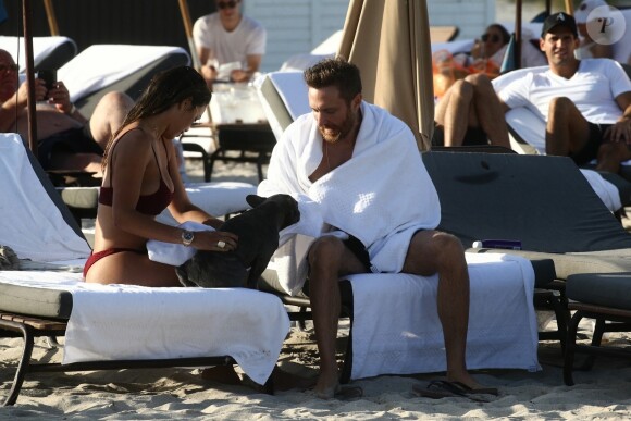 David Guetta et sa compagne Jessica Ledon, qui porte un diamant à l'annulaire gauche, passent du bon temps sur la plage en compagnie de leur petit chien. Miami, le 23 novembre 2018.