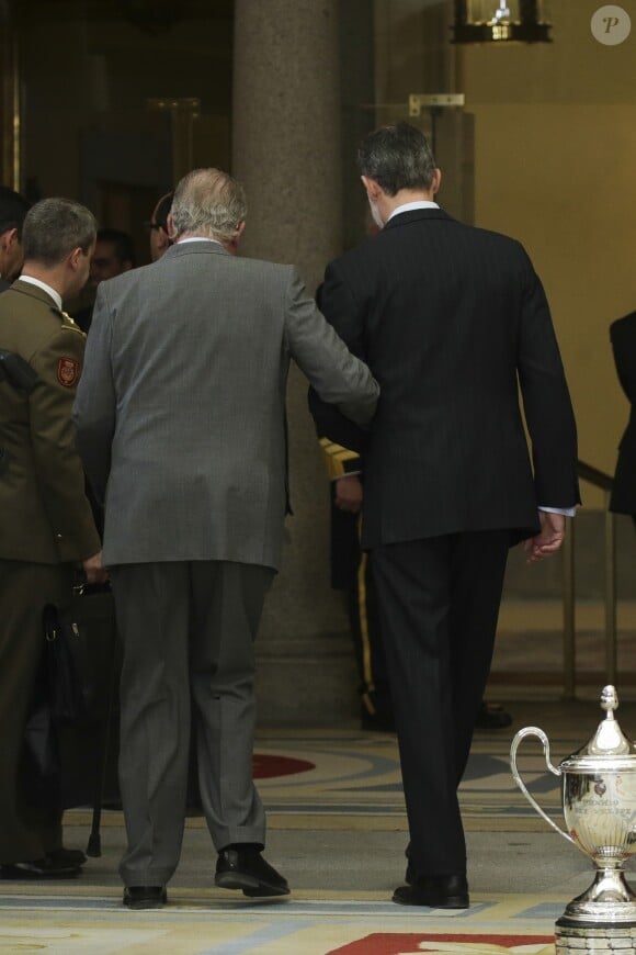 Le roi Felipe VI d'Espagne aidant son père le roi Juan Carlos Ier à se déplacer lors de la cérémonie des Prix nationaux du sport espagnol le 10 janvier 2019 au palais du Pardo, à Madrid.