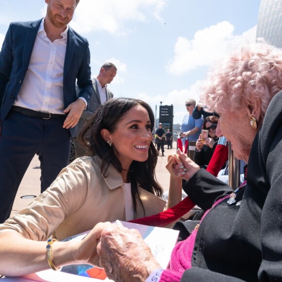 Le prince Harry, duc de Sussex, et Meghan Markle, duchesse de Sussex, rencontrent Daphne Dunne en sortant de l'Opéra de Sydney, le 16 octobre 2018.
