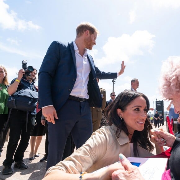 Le prince Harry, duc de Sussex, et Meghan Markle, duchesse de Sussex, rencontrent Daphne Dunne en sortant de l'Opéra de Sydney, le 16 octobre 2018.