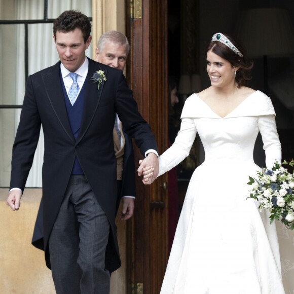 La princesse Eugénie et son mari Jack Brooksbank quittent le château de Windsor après leur mariage à bord d'une Aston Martin le 12 octobre 2018 sous le regard du père de la princesse Eugénie, le Duc d'York, le prince Andrew.