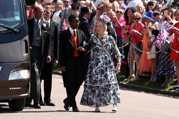 Katharine Worsley, duchesse de Kent, épouse du prince Edward, duc de Kent (en arrière-plan), au mariage du prince Harry et de Meghan Markle à Windsor le 19 mai 2018. La duchesse de Kent portait une robe Erdem qu'on retrouvera un an plus tard sur Kate Middleton, duchesse de Cambridge, lors du Chelsea Flower Show 2019.