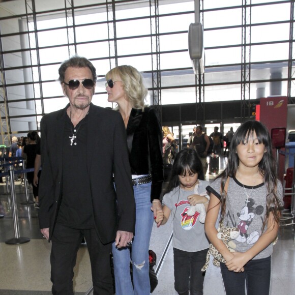 Johnny Hallyday avec sa femme Laeticia et ses enfants Jade et Joy en partance pour Paris arrivent à l'aéroport Lax de Los Angeles le 25 juin 2016.