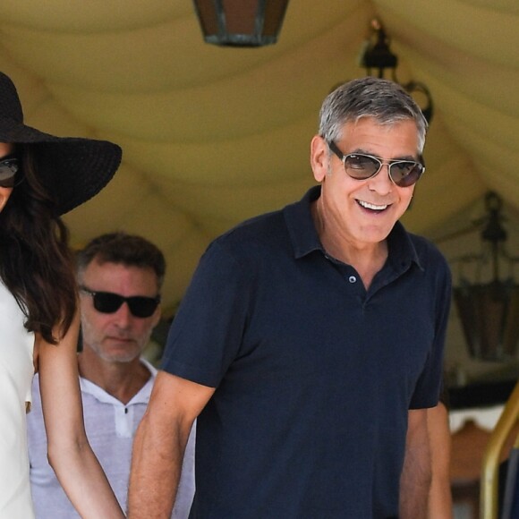 George Clooney et sa femme Amal Clooney sortent de leur hôtel, et prennent un bateau taxi pour se rendre dans un héliport pour s'envoler en hélicoptère de Venise, Italie, le 27 juin 2019.