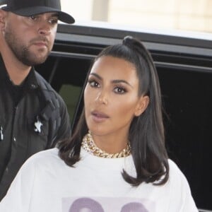 Kim Kardashian porte un t-shirt avec Michael Jackson et Prince à son arrivée à l'aéroport JFK à New York, le 25 juin 2019. Elle porte un cycliste blanc et des baskets Yeezy.