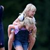 Isla Phillips monte sur le dos de sa soeur Savannah Phillips lors du Festival of British Eventing à Gatcombe Park le 2 août 2019.