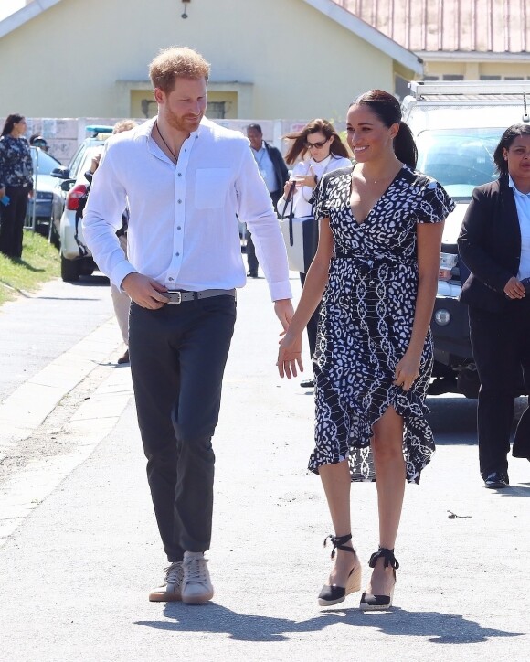 Le prince Harry, duc de Sussex, et Meghan Markle, duchesse de Sussex, arrivent main dans la main en visite dans le township de Nyanga en Afrique du Sud le 23 septembre 2019.