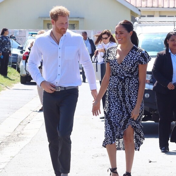 Le prince Harry, duc de Sussex, et Meghan Markle, duchesse de Sussex, arrivent main dans la main en visite dans le township de Nyanga en Afrique du Sud le 23 septembre 2019.