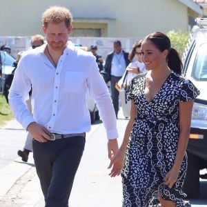 Le prince Harry, duc de Sussex, et Meghan Markle, duchesse de Sussex, arrivent main dans la main en visite dans le township de Nyanga en Afrique du Sud le 23 septembre 2019.