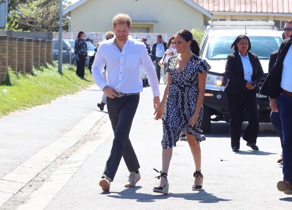 Le prince Harry, duc de Sussex, et Meghan Markle, duchesse de Sussex, arrivent main dans la main en visite dans le township de Nyanga en Afrique du Sud le 23 septembre 2019.