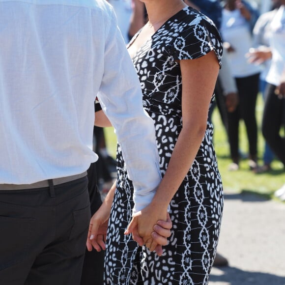 Le prince Harry, duc de Sussex, et Meghan Markle, duchesse de Sussex, arrivent main dans la main en visite dans le township de Nyanga en Afrique du Sud le 23 septembre 2019.