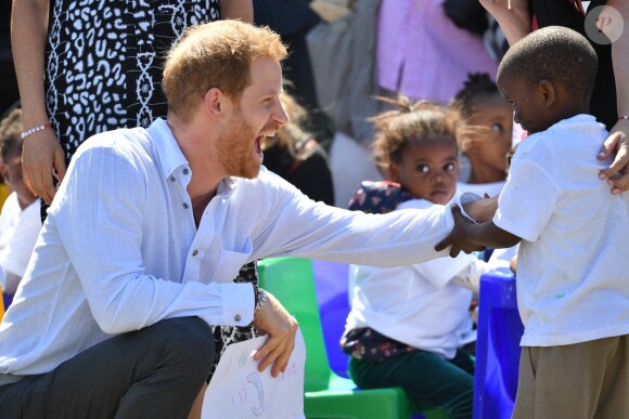 Le prince Harry, duc de Sussex, et Meghan Markle, duchesse de Sussex, arrivent main dans la main en visite dans le township de Nyanga en Afrique du Sud le 23 septembre 2019.