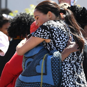 Le prince Harry, duc de Sussex, et Meghan Markle, duchesse de Sussex, arrivent main dans la main en visite dans le township de Nyanga en Afrique du Sud le 23 septembre 2019.