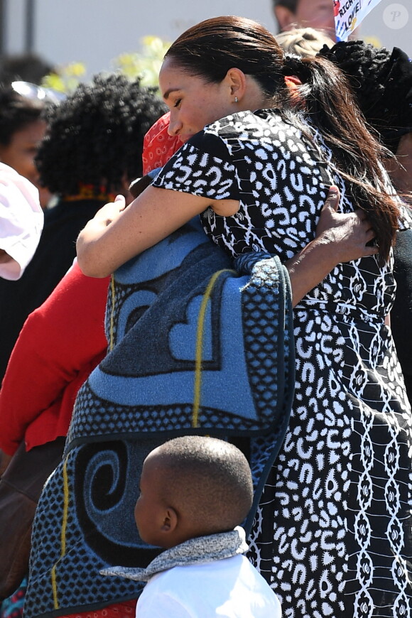 Le prince Harry, duc de Sussex, et Meghan Markle, duchesse de Sussex, arrivent main dans la main en visite dans le township de Nyanga en Afrique du Sud le 23 septembre 2019.