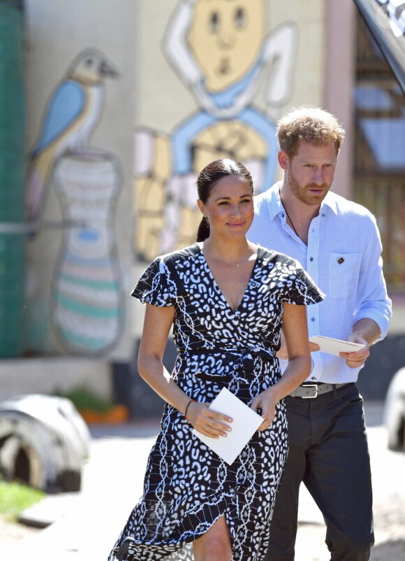 Le prince Harry, duc de Sussex, et Meghan Markle, duchesse de Sussex, arrivent main dans la main en visite dans le township de Nyanga en Afrique du Sud le 23 septembre 2019.