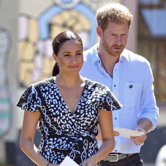 Le prince Harry, duc de Sussex, et Meghan Markle, duchesse de Sussex, arrivent main dans la main en visite dans le township de Nyanga en Afrique du Sud le 23 septembre 2019.