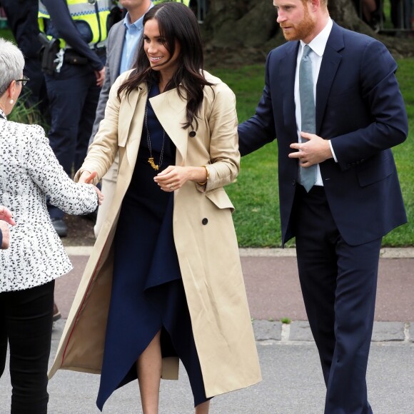 Le prince Harry, duc de Sussex, et Meghan Markle, en trench-coat Martin Grant, vont à la rencontre de la foule venue les accueillir, lors de la visite des jardins botaniques de Melbourne, le 18 octobre 2018.