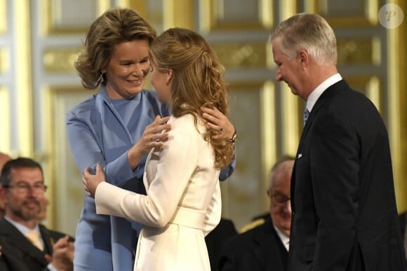 La reine Mathile embrasse avec fierté et émotion sa fille la princesse Elisabeth lors de la célébration de son 18e anniversaire le 25 octobre 2019 dans la Salle du Trône au palais royal à Bruxelles.