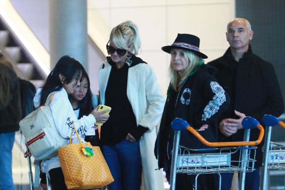 Jade et Joy, Laeticia Hallyday, Jimmy Refas, Françoise Thibault, la mère de Laeticia Hallyday - Laeticia Hallyday arrive en famille avec ses filles et sa mère à l'aéroport Roissy CDG le 19 novembre 2019.