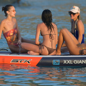 Bella Hadid, Devon Lee Carlson, Laeticia Hallyday, Jesse Jo Stark - Laeticia Hallyday rejoint Bella Hadid et son équipe de shooting sur un paddle géant et se baigne sur une plage de Saint-Barthélemy le 7 décembre 2019.