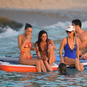 Bella Hadid, Devon Lee Carlson, Laeticia Hallyday, Jesse Jo Stark - Laeticia Hallyday rejoint Bella Hadid et son équipe de shooting sur un paddle géant et se baigne sur une plage de Saint-Barthélemy le 7 décembre 2019.