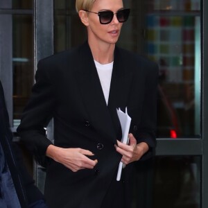 Charlize Theron dans la rue à New York le 12 novembre 2019. elle porte un pantalon lamé argent et une veste de blazer.