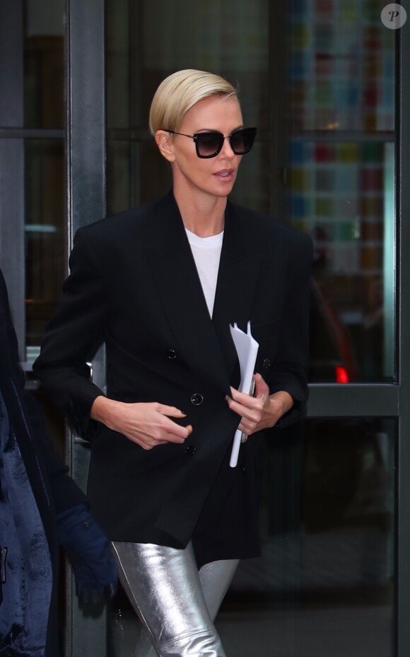 Charlize Theron dans la rue à New York le 12 novembre 2019. elle porte un pantalon lamé argent et une veste de blazer.