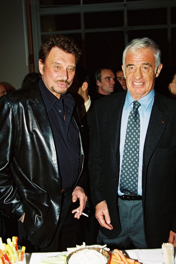 Johnny Hallyday, Jean-Paul Belmondo lors du vernissage de l'exposition des oeuvres de Paul Belmondo "Le Dessin pour Passion" au Petit Palais à Paris, le 20 novembre 2000.