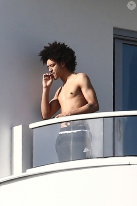 Ahlamalik Williams , le nouveau compagnon de Madonna, fume sur le balcon de son hôtel Faena à Miami. Le 14 décembre 2019.
