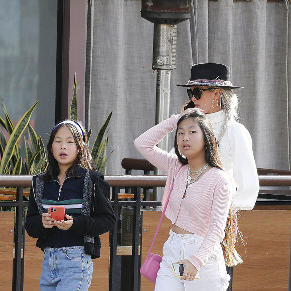 Exclusif - Laeticia Hallyday et ses filles Jade et Joy font du shopping dans une boutique de sport à Santa Monica le 18 janvier 2020. Elles sont ensuite allées déjeuner au restaurant Sushi Roku, avant de rejoindre Mathilde Balland un peu plus loin sur la 3rd Street Promenade à Santa Monica. Jade et Mathilde sont visiblement de plus en plus amies et prennent la pose pour une photo avec Laeticia. Elles sont ensuite allées se promener pendant que Laeticia rentrait avec Joy à la villa.