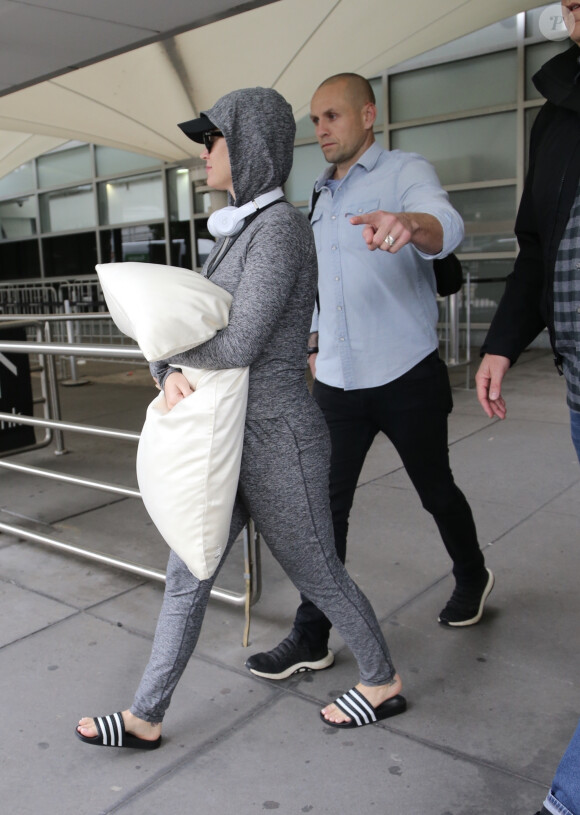 Exclusif - Katy Perry, enceinte de son premier enfant, se couvre le ventre avec un oreiller à son arrivée à Melbourne le 6 mars 2020.