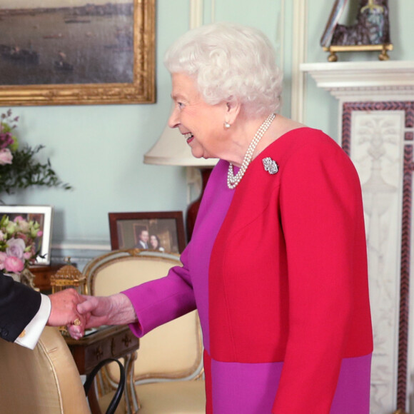 La reine Elizabeth II d'Angleterre se voit remettre la première Médaille en Or de l'Ordre de St John par le professeur Mark Compton lors d'une audience au palais de Buckingham à Londres le 11 mars 2020. En pleine pandémie du coronavirus, la souveraine n'a pas hésité à serrer la main de son visiteur.