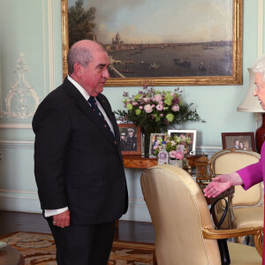 La reine Elizabeth II d'Angleterre se voit remettre la première Médaille en Or de l'Ordre de St John par le professeur Mark Compton lors d'une audience au palais de Buckingham à Londres le 11 mars 2020. En pleine pandémie du coronavirus, la souveraine n'a pas hésité à serrer la main de son visiteur.