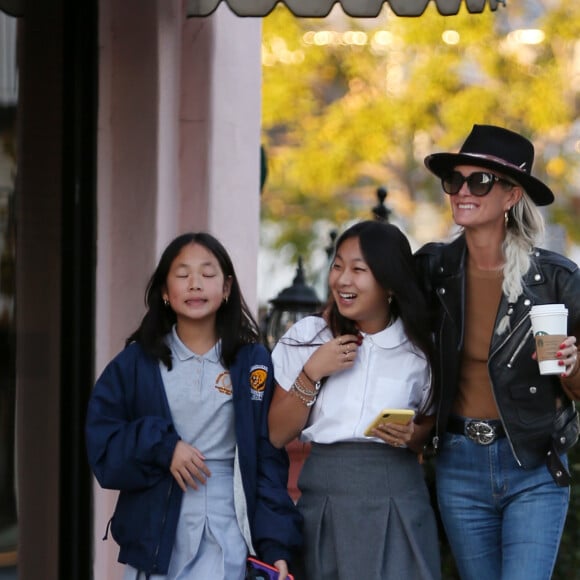 Exclusif - Prix spécial - Laeticia Hallyday et ses filles Jade et Joy font du shopping à Santa Monica le 17 janvier 2020. Sur le retour de l'école elles se sont arrêtées dans une boutique de bougies parfumées confectionnées sur mesure, le Stone Candles Bar. Joy insiste pour aider sa mère à porter le gros carton rempli de bougies qu'elles viennent de récupérer.