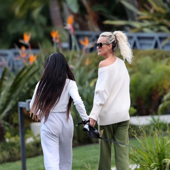 Laeticia Hallyday et ses filles Jade, 15 ans, et Joy, 11 ans, promènent leur chien Cheyenne dans le quartier de Brentwood à Los Angeles, pendant la période de confinement liée à l'épidémie de coronavirus (Covid-19), le 1er avril 2020.