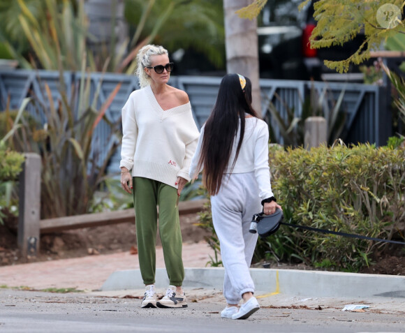 Laeticia Hallyday et ses filles Jade, 15 ans, et Joy, 11 ans, promènent leur chien Cheyenne dans le quartier de Brentwood à Los Angeles, pendant la période de confinement liée à l'épidémie de coronavirus (Covid-19), le 1er avril 2020.