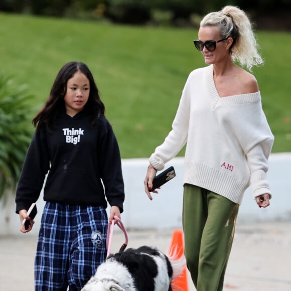 Laeticia Hallyday et ses filles Jade, 15 ans, et Joy, 11 ans, promènent leur chien Cheyenne dans le quartier de Brentwood à Los Angeles, pendant la période de confinement liée à l'épidémie de coronavirus (Covid-19), le 1er avril 2020.