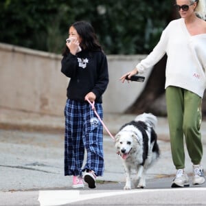 Laeticia Hallyday et ses filles Jade, 15 ans, et Joy, 11 ans, promènent leur chien Cheyenne dans le quartier de Brentwood à Los Angeles, pendant la période de confinement liée à l'épidémie de coronavirus (Covid-19), le 1er avril 2020.