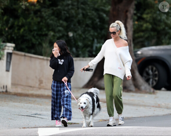 Laeticia Hallyday et ses filles Jade, 15 ans, et Joy, 11 ans, promènent leur chien Cheyenne dans le quartier de Brentwood à Los Angeles, pendant la période de confinement liée à l'épidémie de coronavirus (Covid-19), le 1er avril 2020.