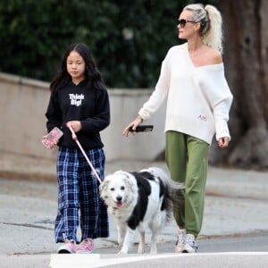 Laeticia Hallyday et ses filles Jade, 15 ans, et Joy, 11 ans, promènent leur chien Cheyenne dans le quartier de Brentwood à Los Angeles, pendant la période de confinement liée à l'épidémie de coronavirus (Covid-19), le 1er avril 2020.