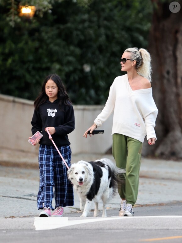 Laeticia Hallyday et ses filles Jade, 15 ans, et Joy, 11 ans, promènent leur chien Cheyenne dans le quartier de Brentwood à Los Angeles, pendant la période de confinement liée à l'épidémie de coronavirus (Covid-19), le 1er avril 2020.