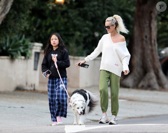Laeticia Hallyday et ses filles Jade, 15 ans, et Joy, 11 ans, promènent leur chien Cheyenne dans le quartier de Brentwood à Los Angeles, pendant la période de confinement liée à l'épidémie de coronavirus (Covid-19), le 1er avril 2020.