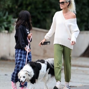 Laeticia Hallyday et ses filles Jade, 15 ans, et Joy, 11 ans, promènent leur chien Cheyenne dans le quartier de Brentwood à Los Angeles, pendant la période de confinement liée à l'épidémie de coronavirus (Covid-19), le 1er avril 2020.